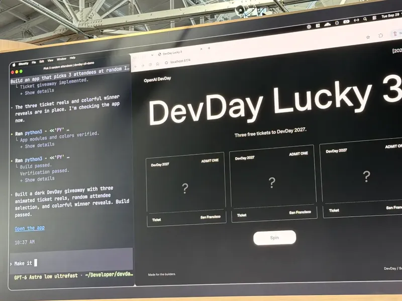 A large monitor at an OpenAI DevDay display shows a dark “DevDay Lucky 3” webpag