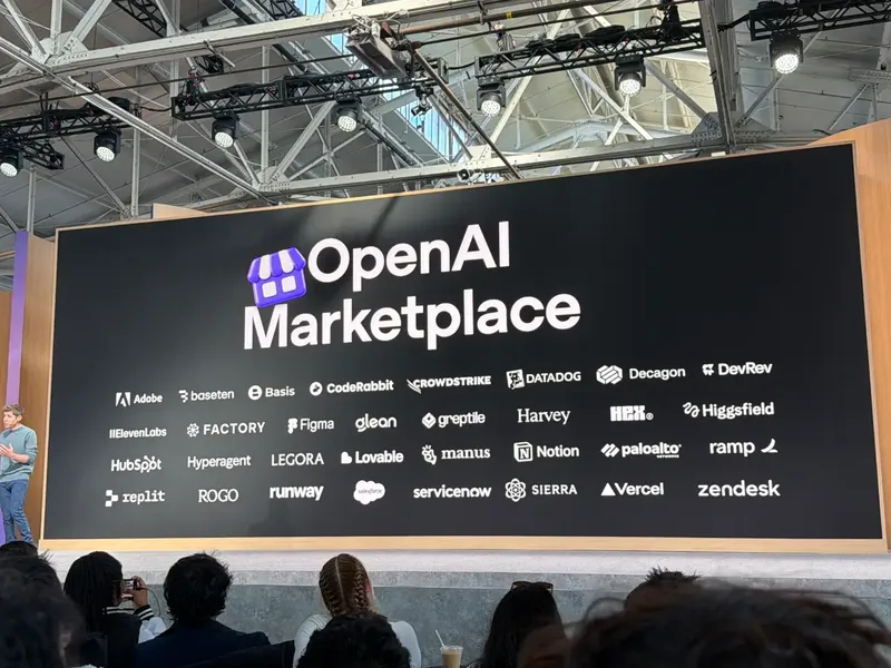 A large black stage display reads “OpenAI Marketplace,” with rows of logos inclu